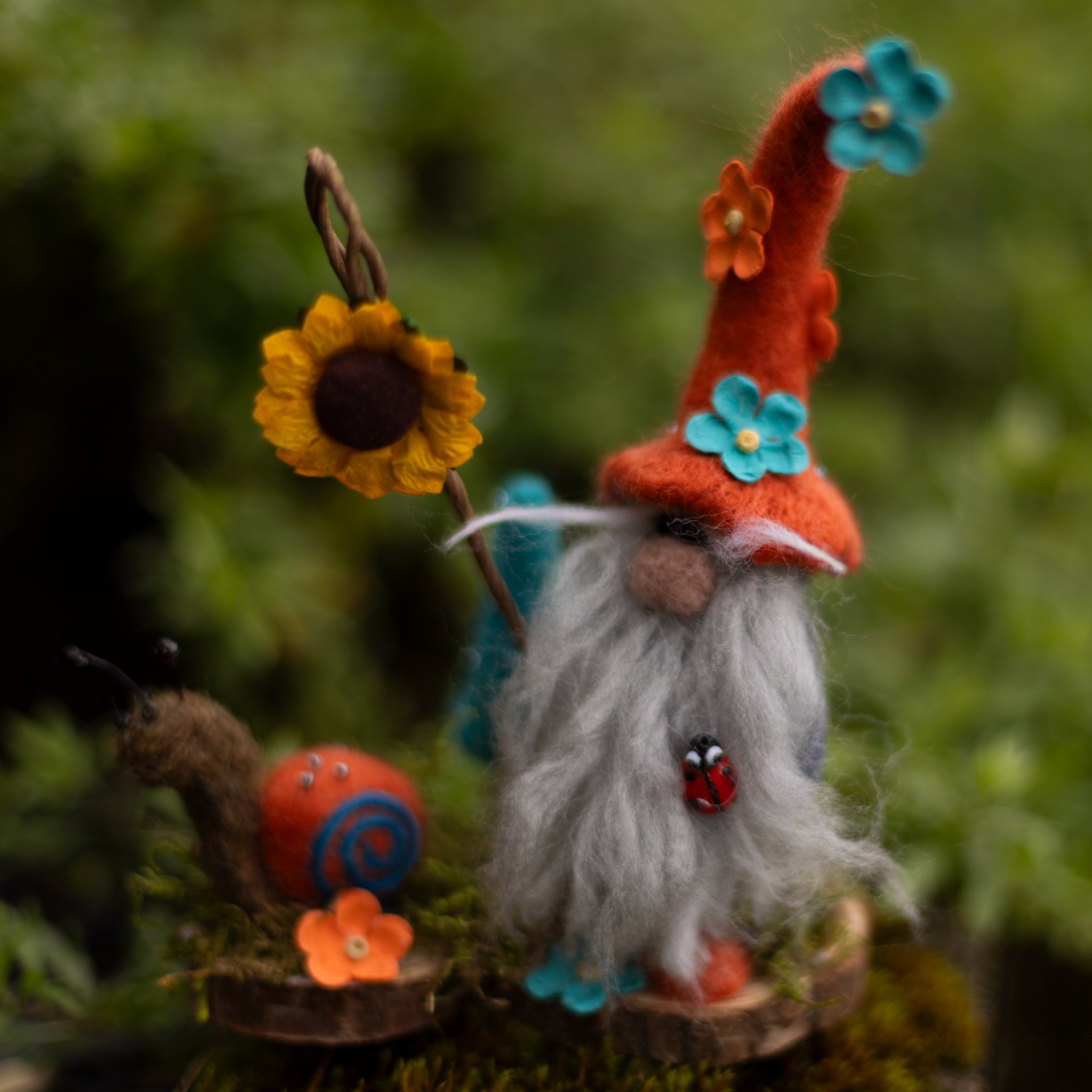 Colourful needle-felted gnome with sunflower and snail.